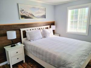 a bedroom with a white bed and a window at The Orchard at Oliver in Oliver