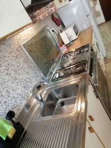 cocina con fregadero y fogones en La casa di Cinzia en Pettorano sul Gizio