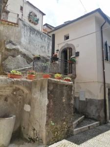 a building with potted plants on the side of it at La casa di Cinzia in Pettorano sul Gizio