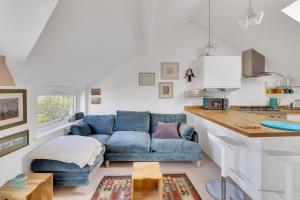 sala de estar con sofá azul y cocina en 1 Bed - Bantham by Pureserviced, en Plymouth