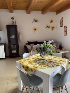 a dining room table with a vase of flowers on it at Słonecznikowe gniazdko in Miłomłyn