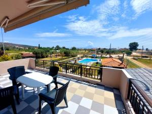 a balcony with a table and chairs and a pool at House Michalis in Sarti