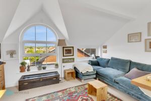 a living room with a blue couch and a window at 1 Bed - Bantham by Pureserviced in Plymouth