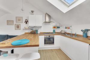 a kitchen with white cabinets and a wooden counter top at 1 Bed - Bantham by Pureserviced in Plymouth