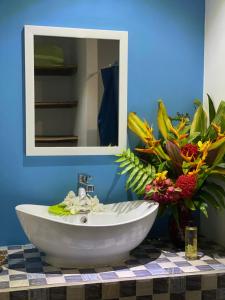 a bathroom with a white sink and a mirror at Vaiotaha Lodge in Bora Bora
