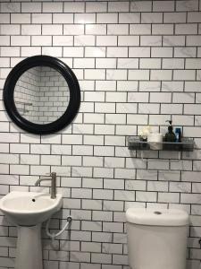 een badkamer met een wastafel, een toilet en een spiegel bij Abe cottage in Kampung Kuala Besut