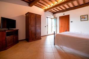 a bedroom with a bed and a flat screen tv at Casale Rancaglia in Gubbio