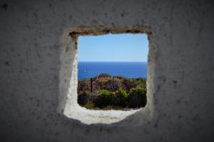 a view of the ocean through a hole in a wall at Summer Residence in Provatas