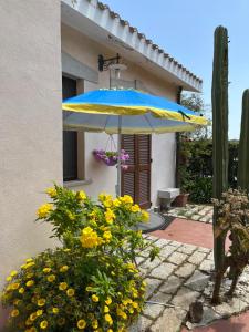 a blue and yellow umbrella in front of a house at Villa Iris in Iglesias