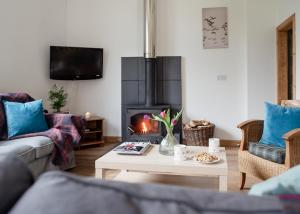 a living room with a couch and a fire place at The Post House - Seasgair Lodges in Kingussie