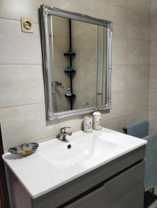ein Badezimmer mit einem weißen Waschbecken und einem Spiegel in der Unterkunft Apartamento T2 in Vila Praia de Âncora