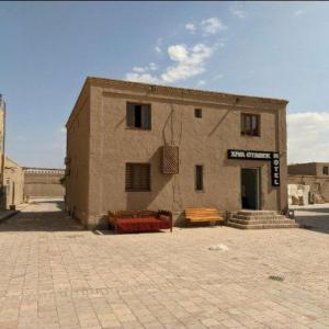 um edifício com dois bancos à sua frente em Khiva Otabek Hotel em Khiva