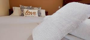 a white bed with a love pillow on it at House Michalis in Sarti