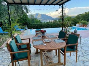 a wooden table and chairs in front of a pool at Villa Sikia in Katokhórion