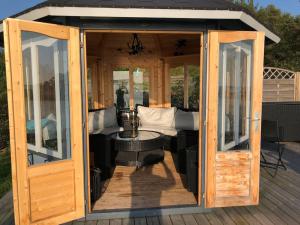 um gazebo de madeira com uma mesa em Cottage with own beach, seaterrace & pavillion. em Mariehamn