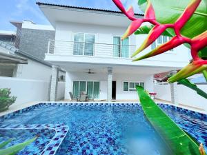 a villa with a swimming pool in front of a house at Relax Pool Villa Near Walking Street,jacuzzi ,BBQ 5Bed 6Bath City house54 in Pattaya South