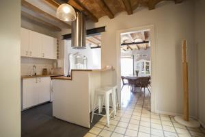 a kitchen with white cabinets and a table with chairs at 41COB1019- Charming rustic apartment in Barcelona