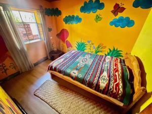 a bedroom with a bed with a colorful wall at Refugio Terra Esperanza in Ibarra
