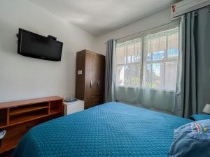 a bedroom with a bed and a television on the wall at A Primeira Vista in Florianópolis