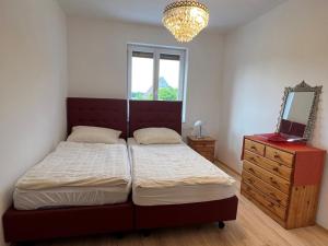 a bedroom with a bed and a mirror and a dresser at Ferienzimmer zwischen Wien und Tulln in Tulln