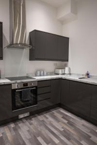 a kitchen with black cabinets and white counter tops at #20 Grimston St 2 bedroom apartment near Hull New Theatre in Hull