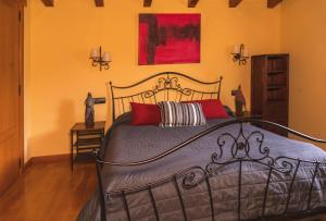 a bedroom with a black bed with red pillows at LAIZARRONDO in Arantza
