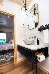 baño con lavabo, espejo y cama en Stone Cove Waterfront Adults Only B&B, en Tobermory