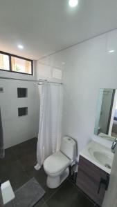 een witte badkamer met een toilet en een wastafel bij Vista Hermosa Glamping y Cabañas in La Mesa