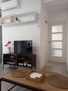 ein Wohnzimmer mit einem Tisch und einem TV in der Unterkunft Apartamento Carabanchel Castizo in Madrid