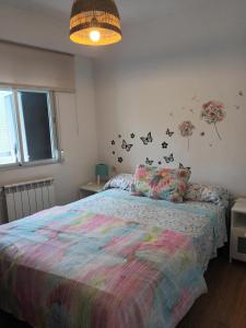 a bedroom with a bed with a colorful comforter at Apartamento Carabanchel Castizo in Madrid