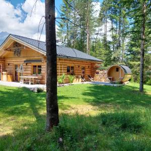 a log cabin in the woods with a tent at Ferienhaus - Chalet - Lechtraum in Stanzach