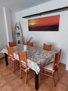 une salle à manger avec une table, des chaises et un tableau dans l'établissement El Nido de Candeleda, à Candeleda