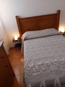 - une chambre avec un lit et une tête de lit en bois dans l'établissement El Nido de Candeleda, à Candeleda