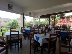 um restaurante com mesas e cadeiras e janelas grandes em Quinta Da Montanha em Rui Vaz