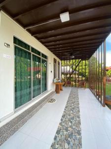 a porch of a house with a large glass door at HOMESTAY JERAI GEOPARK in Guar Chempedak