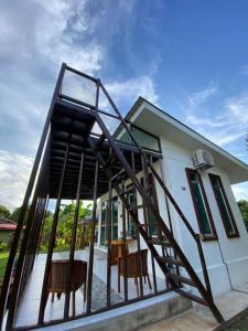 ein Haus mit einer Treppe, die auf einen Balkon führt in der Unterkunft HOMESTAY JERAI GEOPARK in Guar Chempedak