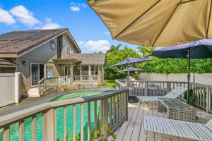 a deck with an umbrella and chairs and a swimming pool at Emmalani 3BR Princeville Villa with Private Pool in Princeville