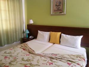 um quarto com uma cama grande com lençóis brancos e almofadas amarelas em Quinta Da Montanha em Rui Vaz