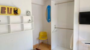 a room with a door and a yellow chair at Casa da Lagoa in Sesimbra