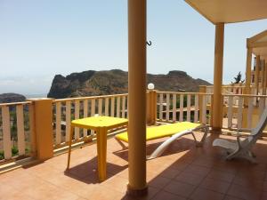 a balcony with a yellow table and a yellow chair at Quinta Da Montanha in Rui Vaz