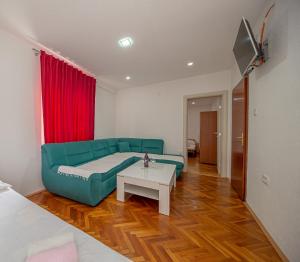 salon z zieloną kanapą i stołem w obiekcie Apartment Marcic w Barze