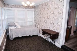 ein Schlafzimmer mit einem kleinen Bett und einem Tisch in der Unterkunft Granny's House by The Coleman Vault in Aurora