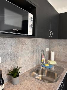 un bancone della cucina con lavello e forno a microonde di Grom Ribno Apartments a Bled