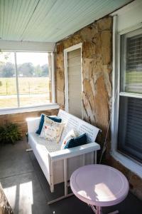 eine Veranda mit einem weißen Sofa und einem Tisch in der Unterkunft Granny's House by The Coleman Vault in Aurora