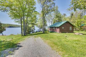 una casa en la orilla de un lago con un camino de tierra en Picturesque Maine Getaway with Lake Access!, en Rangeley