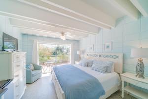 a bedroom with a bed and a chair and a window at Cool Breeze Home in Inlet Beach