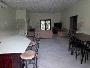 ein Wohnzimmer mit Stühlen, einem Tisch und einem Sofa in der Unterkunft kdk villa in Buccoo