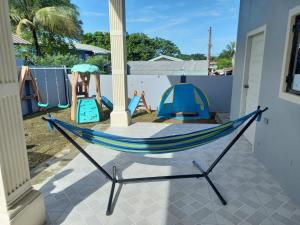 a hammock on a patio with a playground at kdk villa in Buccoo