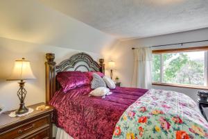 1 dormitorio con 1 cama con edredón morado y ventana en Sunny Cedaredge Home with Mtn Views - Hike and Fish!, en Cedaredge