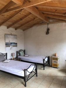 two beds in a room with wooden ceilings at Lucia del Mar in Vouníon